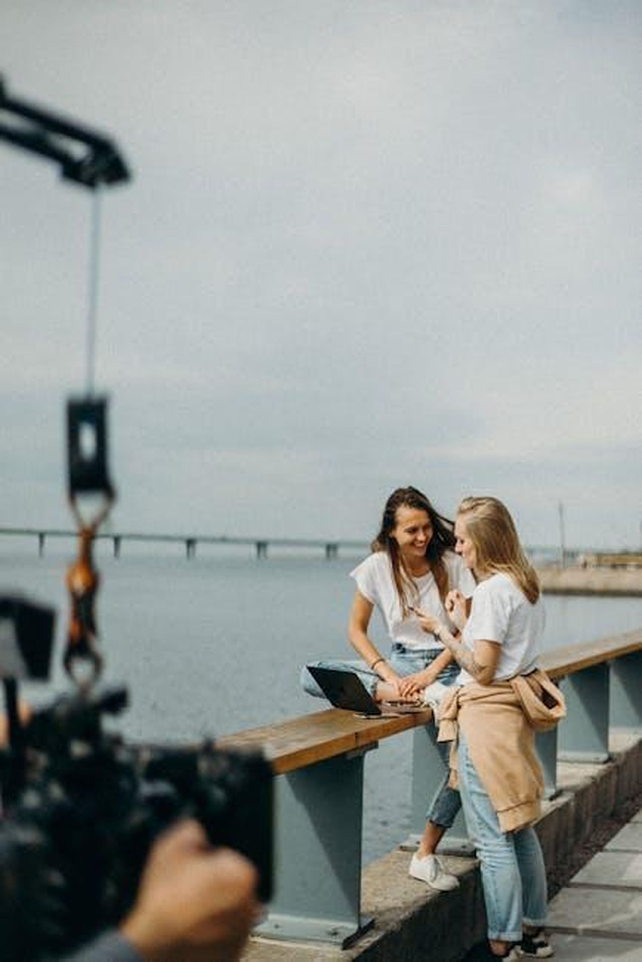 Possibili_collaborazioni_future_2iaTiJHpUA - Confidenze24 Source: cottonbro studio - pexels - Two women enjoying a casual photo shoot by a scenic urban waterfront.