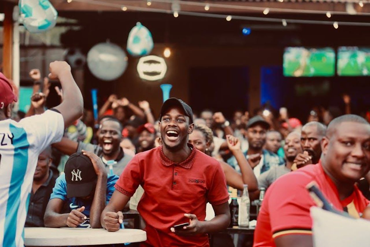 Posso_dirlo_N3OJhhHdC0 - Confidenze24 Source: Karl Rayson - pexels - A lively group of fans enthusiastically cheering at a sports bar during a live match.