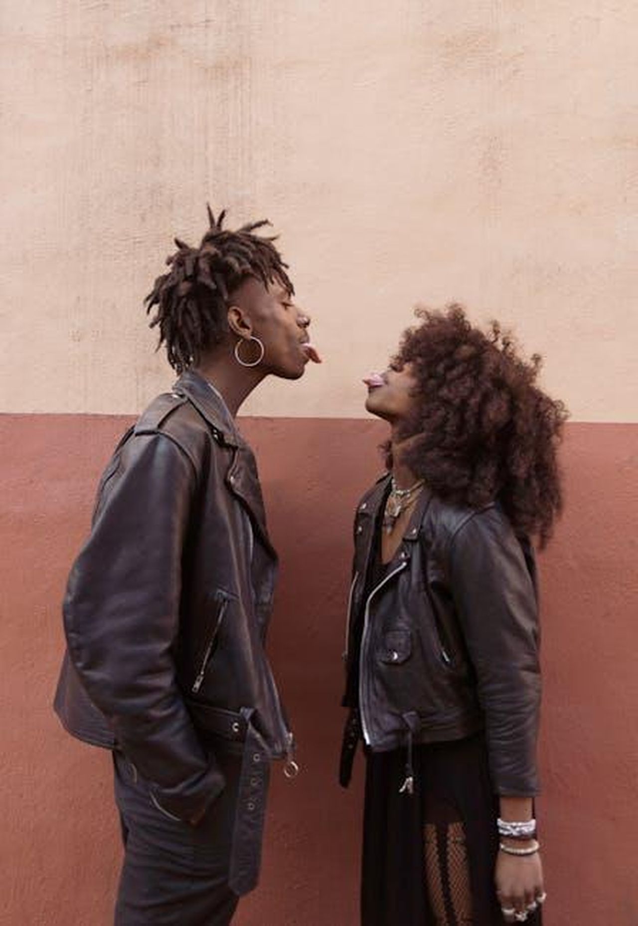 Potrebbero_riconciliarsi_tkERUb66FM - Confidenze24 Source: Brian Jr Asare - pexels - A couple shares a playful moment face to face, both wearing trendy leather jackets, expressing fun and humor.