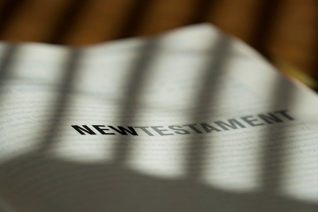 Preparati_per_ritardi_e_rivelazioni_xkzWFCVYE6 - Confidenze24 Source: Christiane - pexels - Close-up image of the New Testament with dramatic shadowing, perfect for religious and spiritual content.