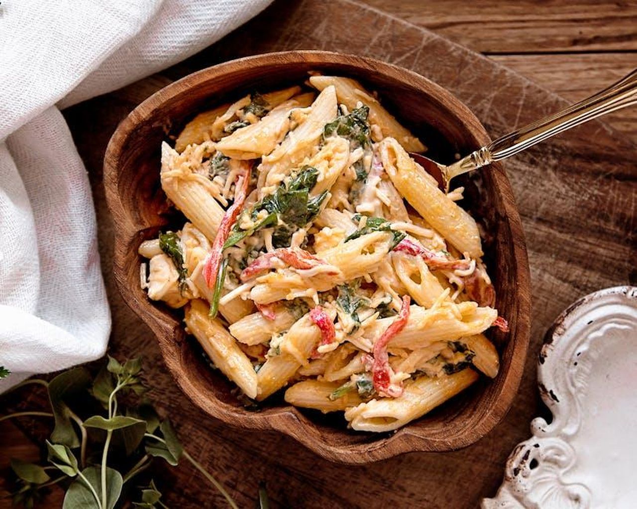 Preparazione_dellInsalata_di_Pasta_Sunshine_nVTLmsA65q - Confidenze24 Source: Eneida Nieves - pexels - A mouth-watering creamy pasta salad with fresh vegetables served in a rustic wooden bowl.