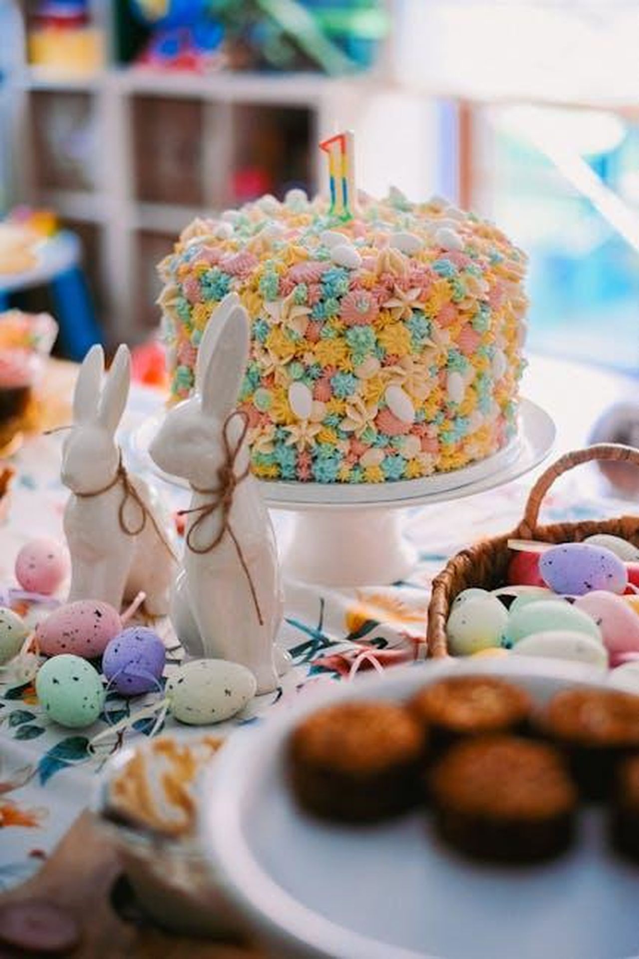 Preparazione_delle_carote_di_cheesecake_NvcKm0L3Cc - Confidenze24 Source: Daka - pexels - Vibrant and festive Easter cake surrounded by Easter eggs and ceramic rabbits on a table.
