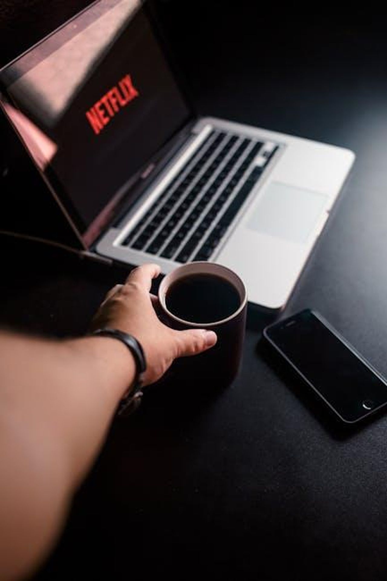 Qual__il_costo_di_un_abbonamento_a_Disney_9zfmaRsoi8 - Confidenze24 Source: Junior Teixeira - pexels - A hand reaching for coffee by a laptop streaming Netflix. Cozy, tech-infused leisure moment.