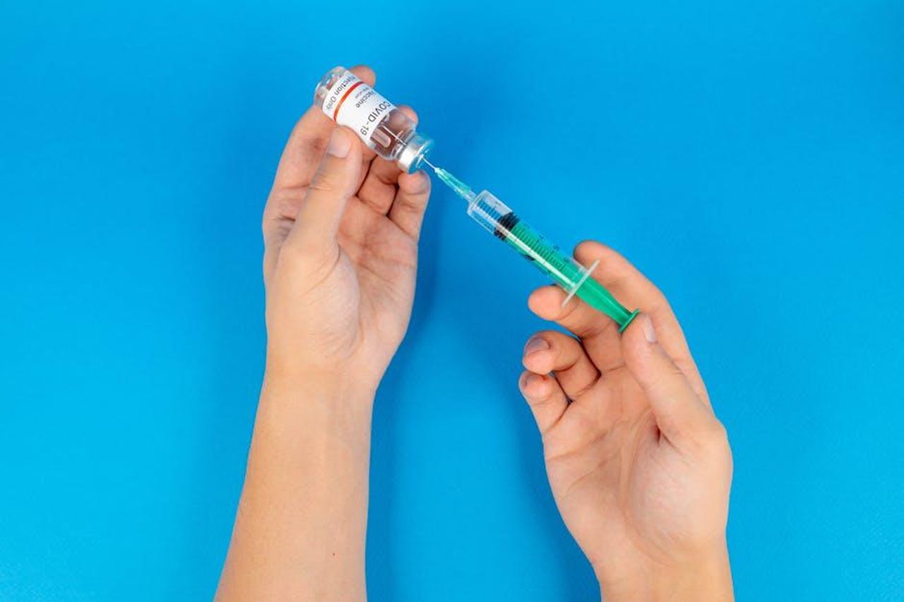 Quali_sono_le_probabilit_di_contrarre_morbillo_se_vaccinato_7JBZ8Byxfs - Confidenze24 Source: Maksim Goncharenok - pexels - Hands holding a syringe and COVID-19 vaccine vial on a blue background.