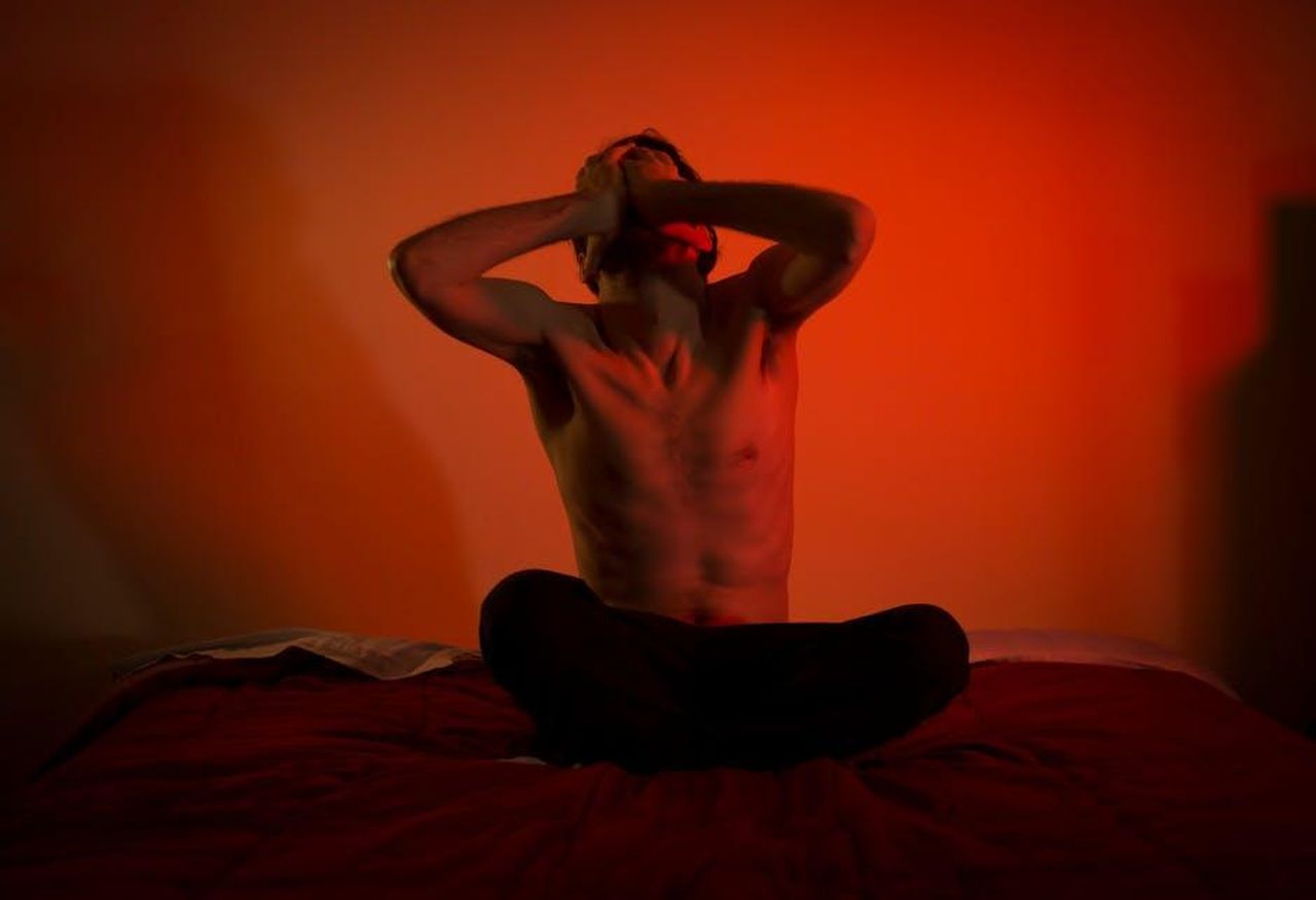 Quando_Stephen_Fry__scomparso_xxHo4p0kAh - Confidenze24 Source: Gioele Fazzeri - pexels - A topless man showing emotional distress sitting on a bed in a dimly lit room.