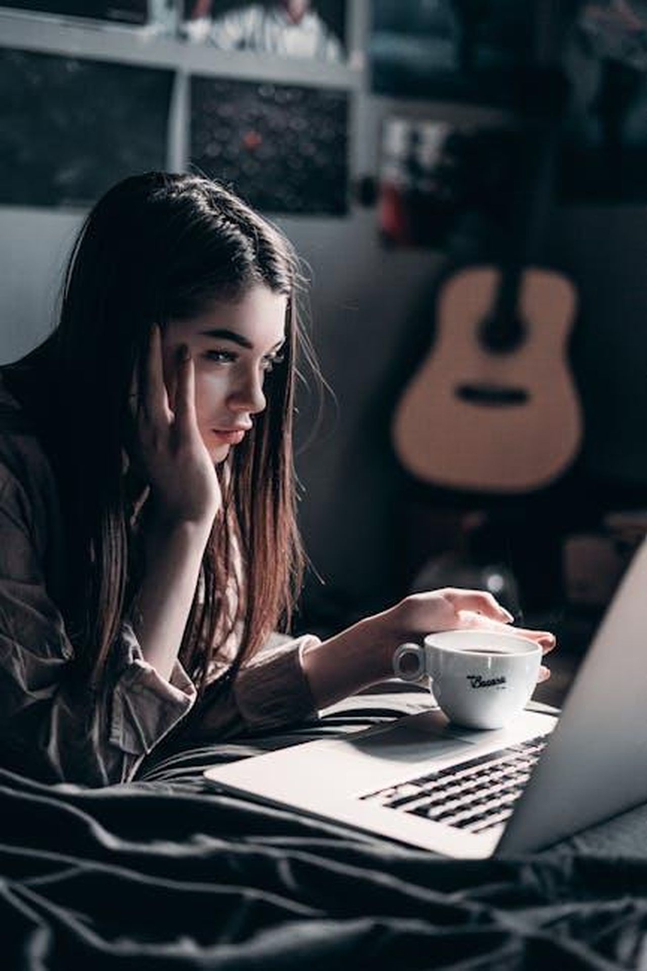 Quando_esce_The_Residence_cUhYLEXyh4 - Confidenze24 Source: Elijah O'Donnell - pexels - Woman lying on bed, focused on laptop with a coffee cup in hand, embracing remote work lifestyle.
