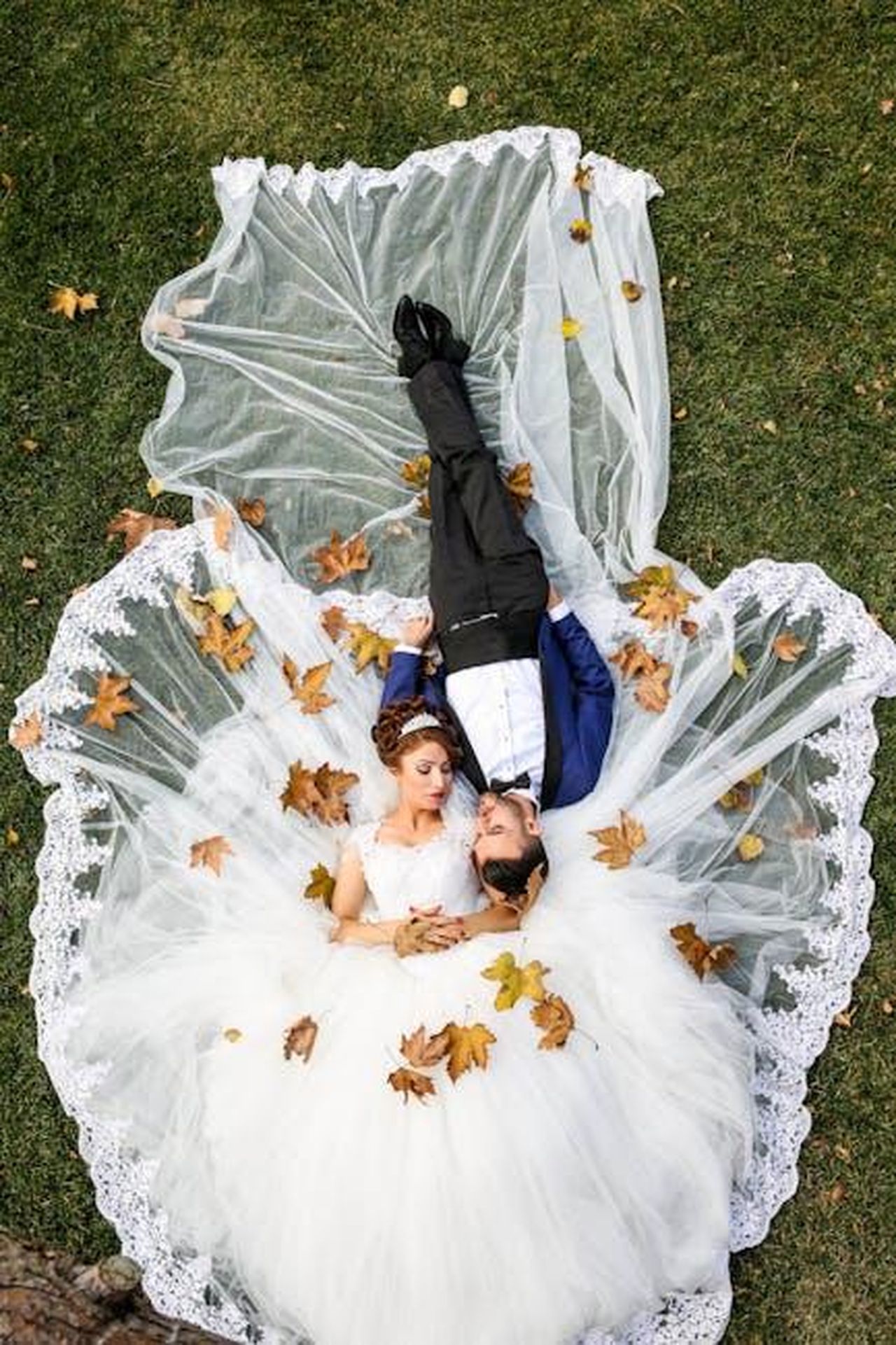 Quando_si_sono_sposati_Randall_Park_e_Jae_Suh_Park_SOVONRFSQB - Confidenze24 Source: Pixabay - pexels - Bride and groom lying together on a lawn surrounded by autumn leaves, captured from above.