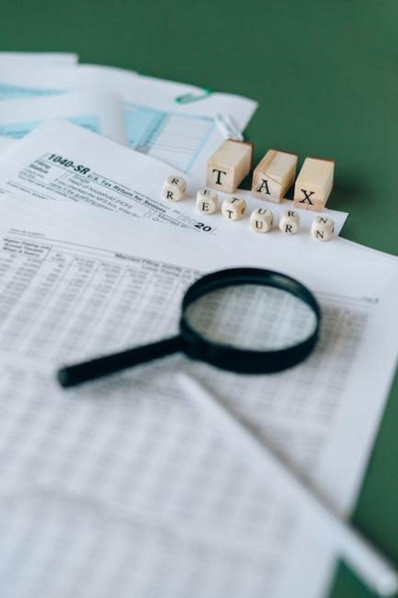 Quando_torna_SWAT_kGgyHJZT8t - Confidenze24 Source: Nataliya Vaitkevich - pexels - Financial documents and magnifying glass highlight tax season analysis.