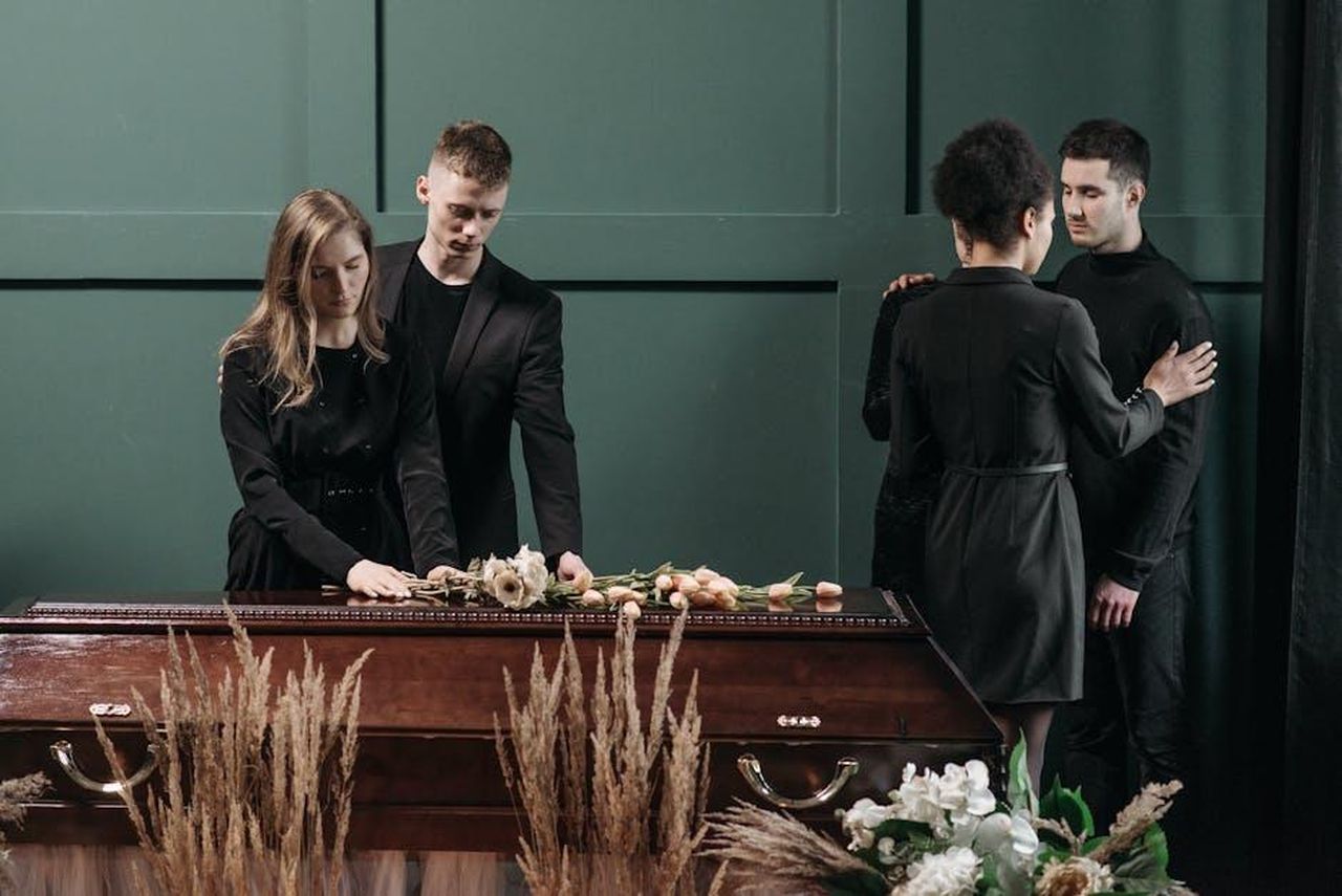 Reazioni_alla_morte_di_Young_Scooter_Kk10Q4Ja2H - Confidenze24 Source: Pavel Danilyuk - pexels - A touching funeral scene with people paying respects to a loved one.