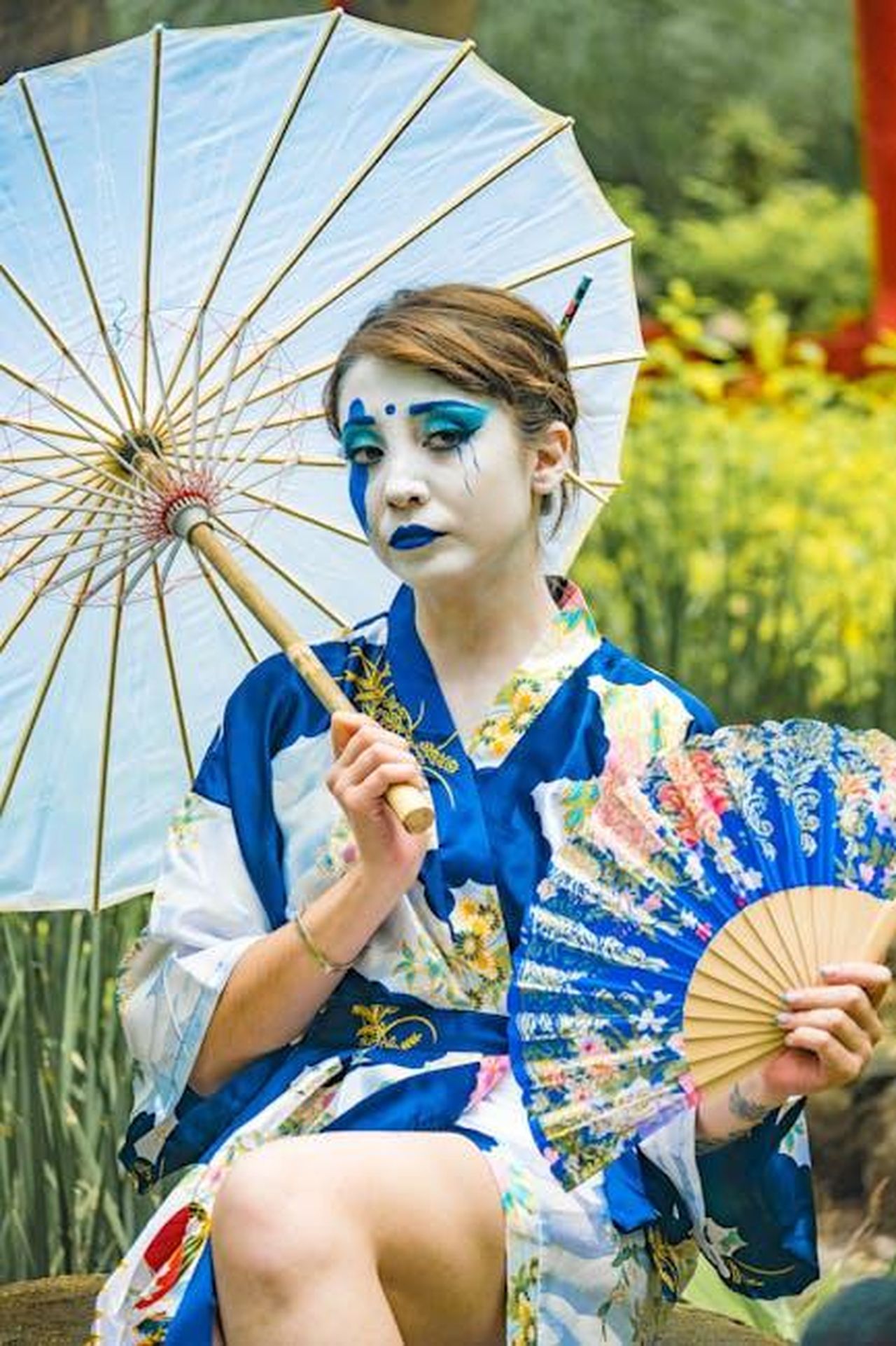 Reazioni_dei_Fan_e_dei_Colleghi_RdCPnqWl9H - Confidenze24 Source: Yuriko Salazar Luna - pexels - Woman in traditional kimono holding an umbrella and fan in a serene garden setting.