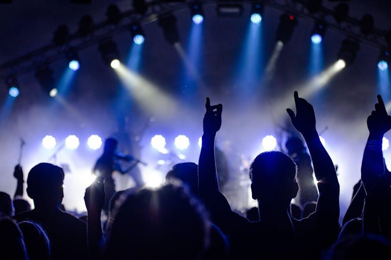 Reazioni_dei_fan_al_sneak_peek_del_reunion_di_Married_to_Medicine_WhtkmA3EqJ - Confidenze24 Source: Wolfgang - pexels - Silhouetted audience enjoying a live band performance with dramatic lighting at night.