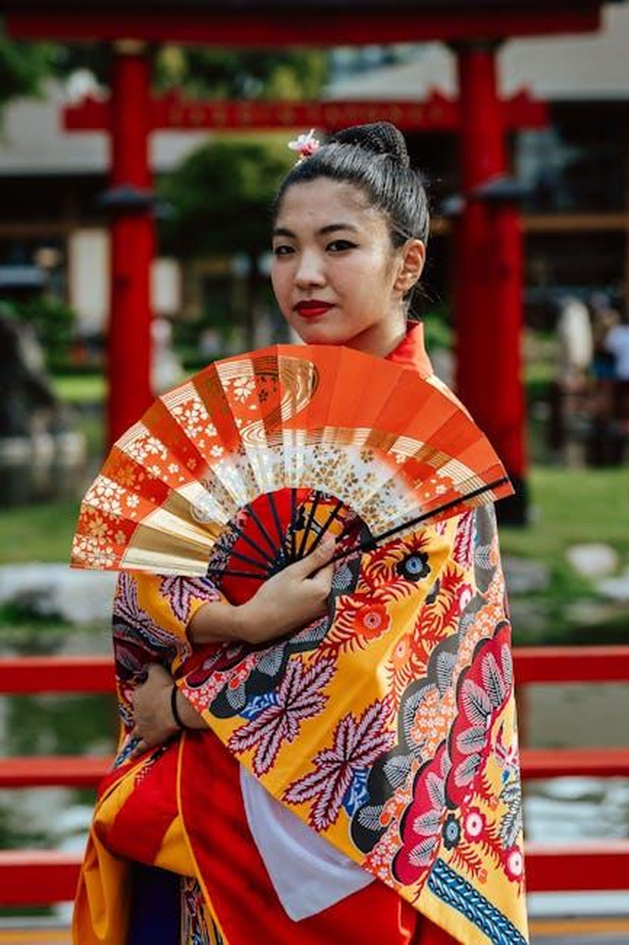 Reazioni_dei_fan_e_tradizione_annuale_rdeAAQ88rn - Confidenze24 Source: Gera Cejas - pexels - Woman in vibrant kimono with fan in Buenos Aires Japanese garden.