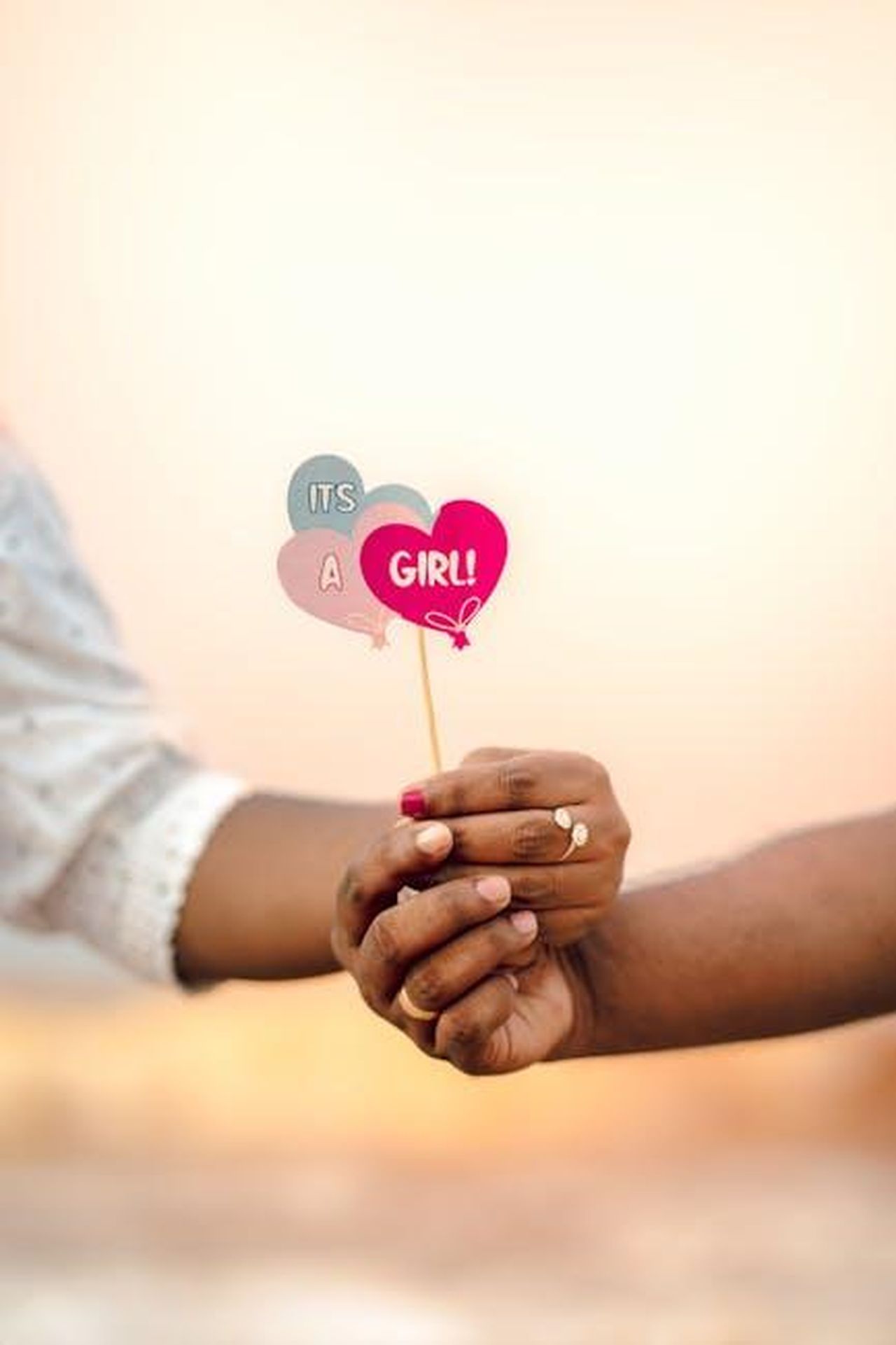 Reazioni_dei_fan_jm5CvgmiT2 - Confidenze24 Source: Nandhu Kumar - pexels - Hands holding a sign announcing 'It's a Girl!' during a heartwarming gender reveal.
