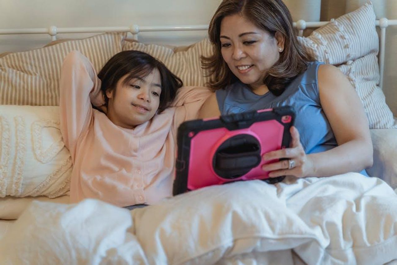 Reazioni_dei_follower_alla_foto_0wVWO2dMWk - Confidenze24 Source: Nicola Barts - pexels - Mother and daughter bonding over a tablet in a cozy home setting.