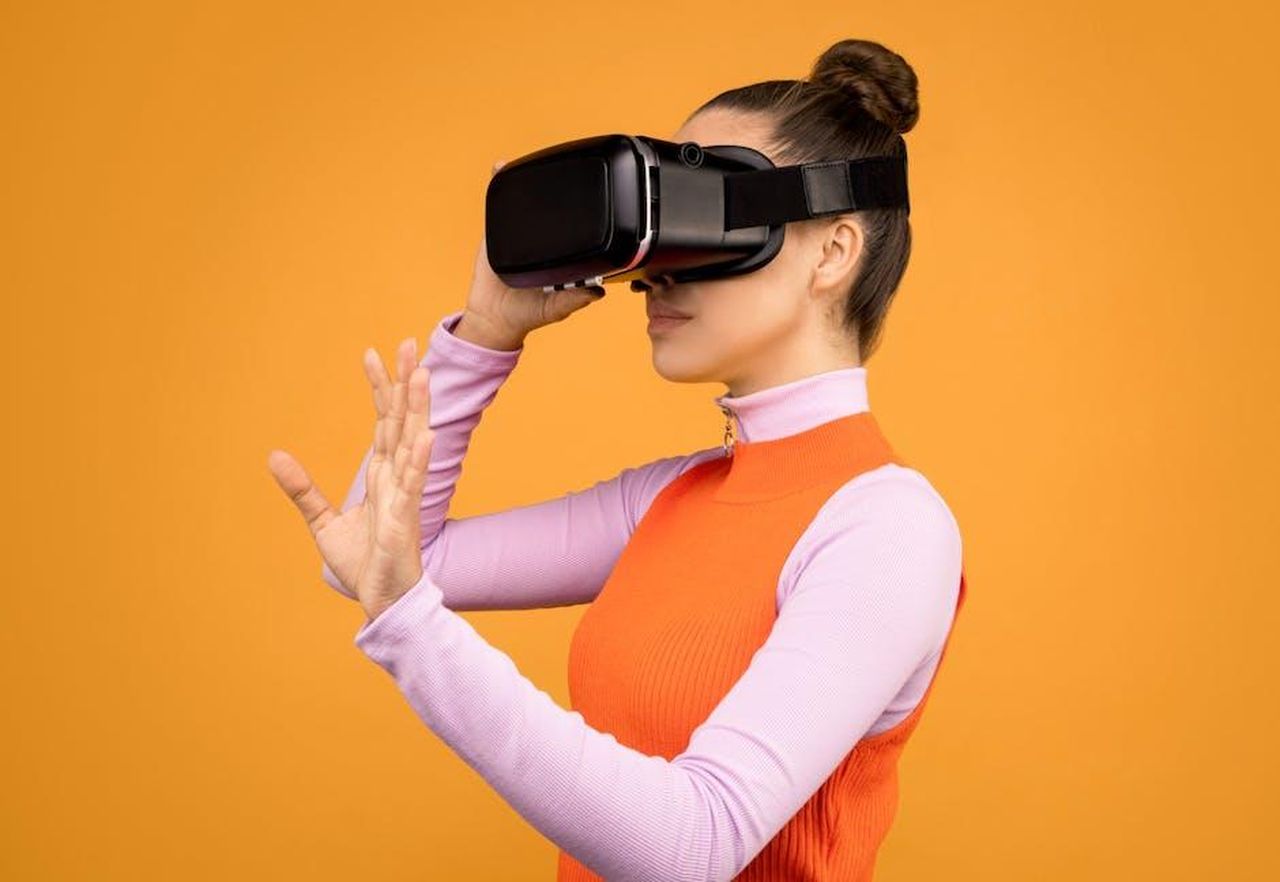 Reazioni_dei_telespettatori_qtmjURtgTu - Confidenze24 Source: Sound On - pexels - Woman with VR headset immersed in a virtual reality experience against an orange background.