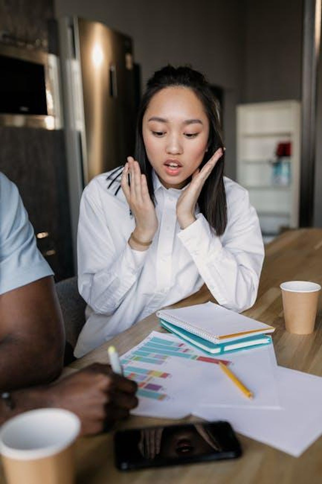 Reazioni_del_mondo_degli_affari_sjK72MvQF1 - Confidenze24 Source: Alena Darmel - pexels - Asian businesswoman in white dress shirt reacts during a team meeting in a modern office.