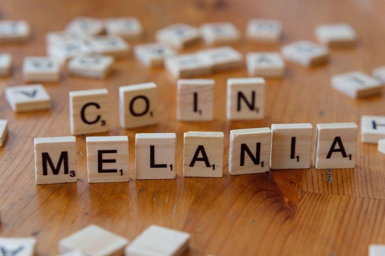 Reazioni_della_famiglia_Trump_mog77F8IHR - Confidenze24 Source: Markus Winkler - pexels - Close-up of Scrabble tiles spelling 'Melania' and 'Coin' on a wooden table, game concept.