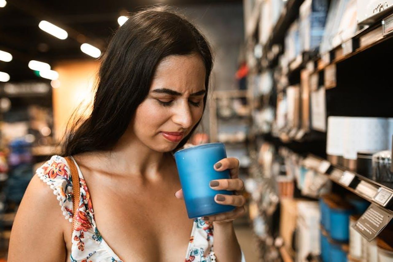 Recensioni_e_feedback_degli_utenti_7MqDMdT9SN - Confidenze24 Source: RDNE Stock project - pexels - A young woman in a floral dress experiences an unpleasant scent while shopping.
