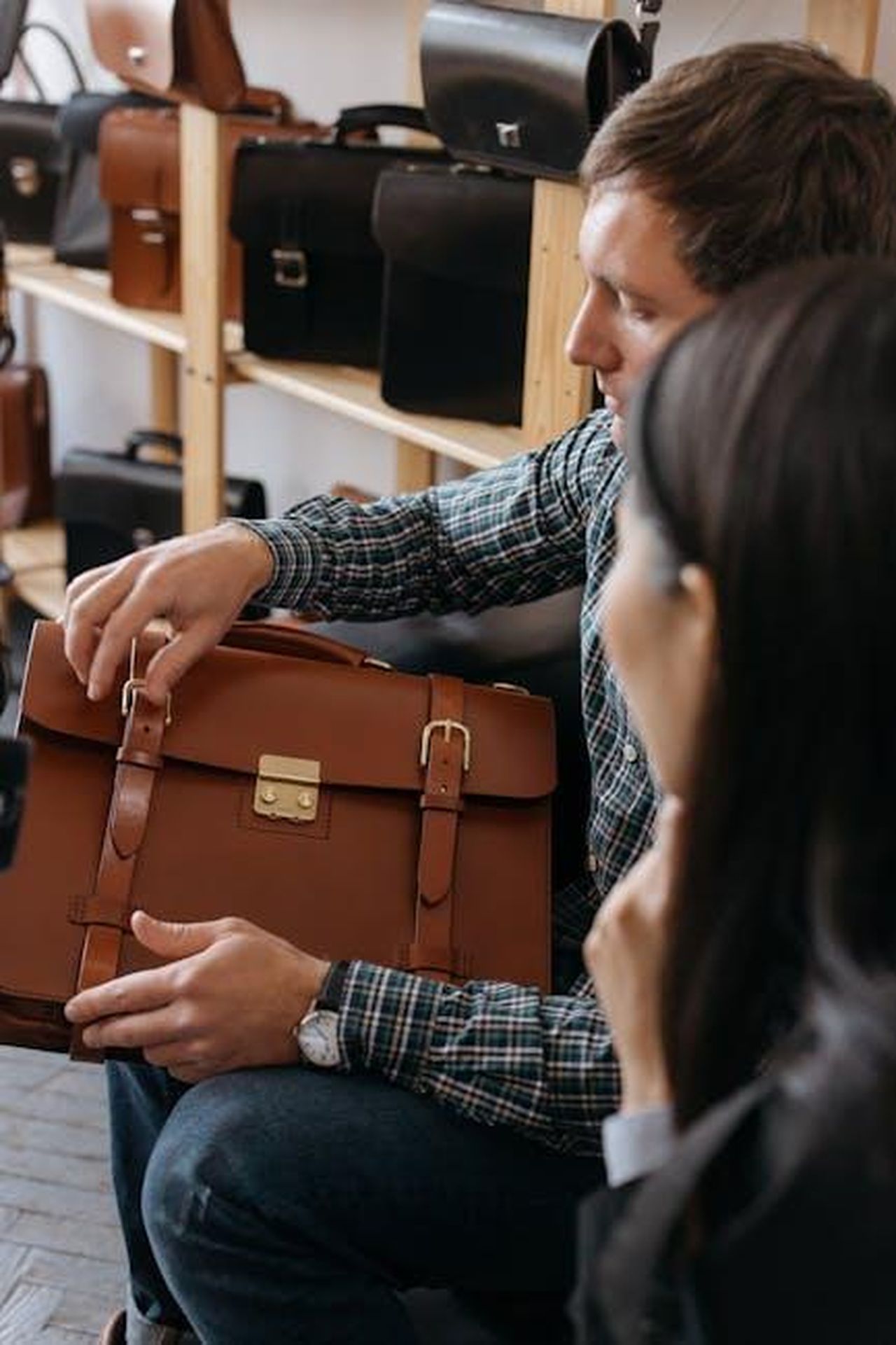 Recensioni_e_feedback_degli_utenti_S7KnxBB8nz - Confidenze24 Source: cottonbro studio - pexels - A man sits indoors examining a stylish leather briefcase in a store setting.