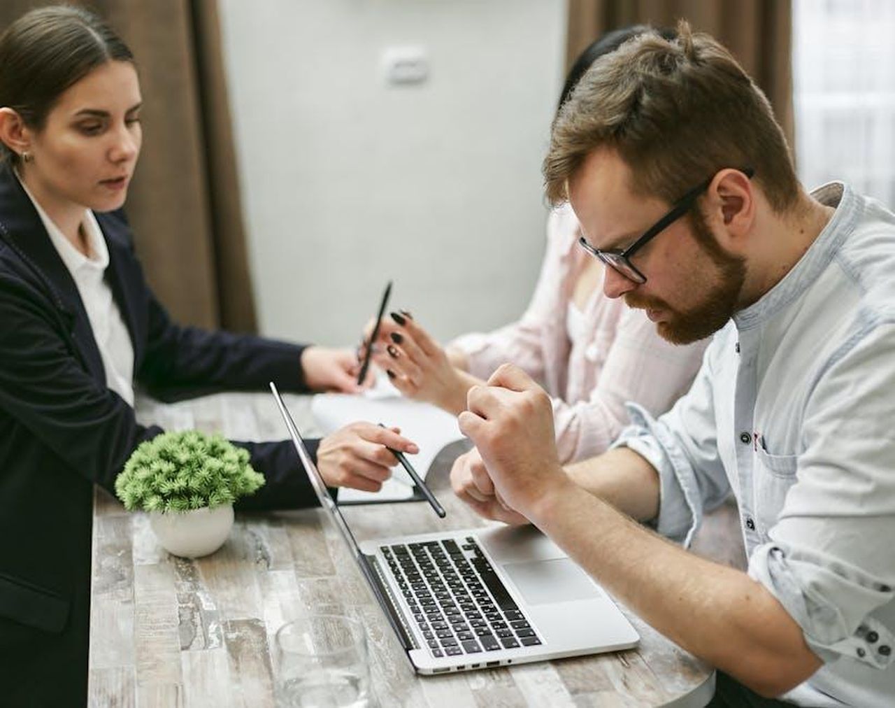 Recensioni_e_testimonianze_sul_Purriko_IOc1ATON3n - Confidenze24 Source: Mikhail Nilov - pexels - Three professionals engage in a collaborative meeting, discussing ideas over a laptop in an office setting.