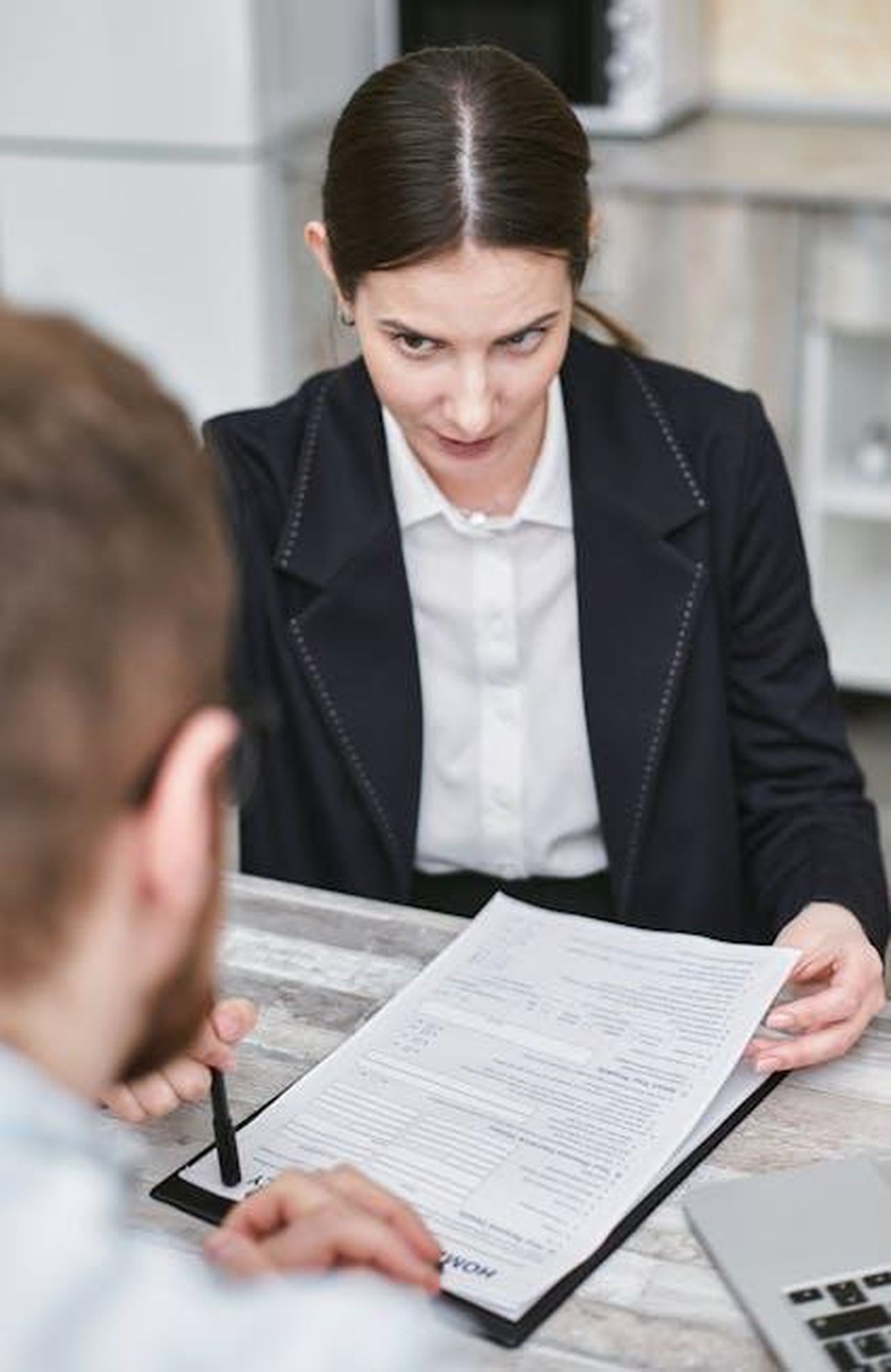Recensioni_entusiastiche_dei_clienti_wYPYlpLKt4 - Confidenze24 Source: Mikhail Nilov - pexels - Professional business meeting with a female executive reviewing a contract with a client.