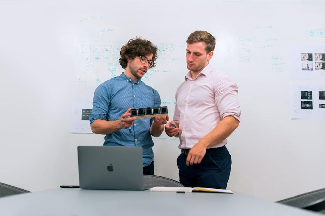 Recensioni_entusiastiche_per_Cliganic_Jojoba_Oil_HIR4n1X744 - Confidenze24 Source: ThisIsEngineering - pexels - Two men in an office discussing and reviewing a tech prototype.