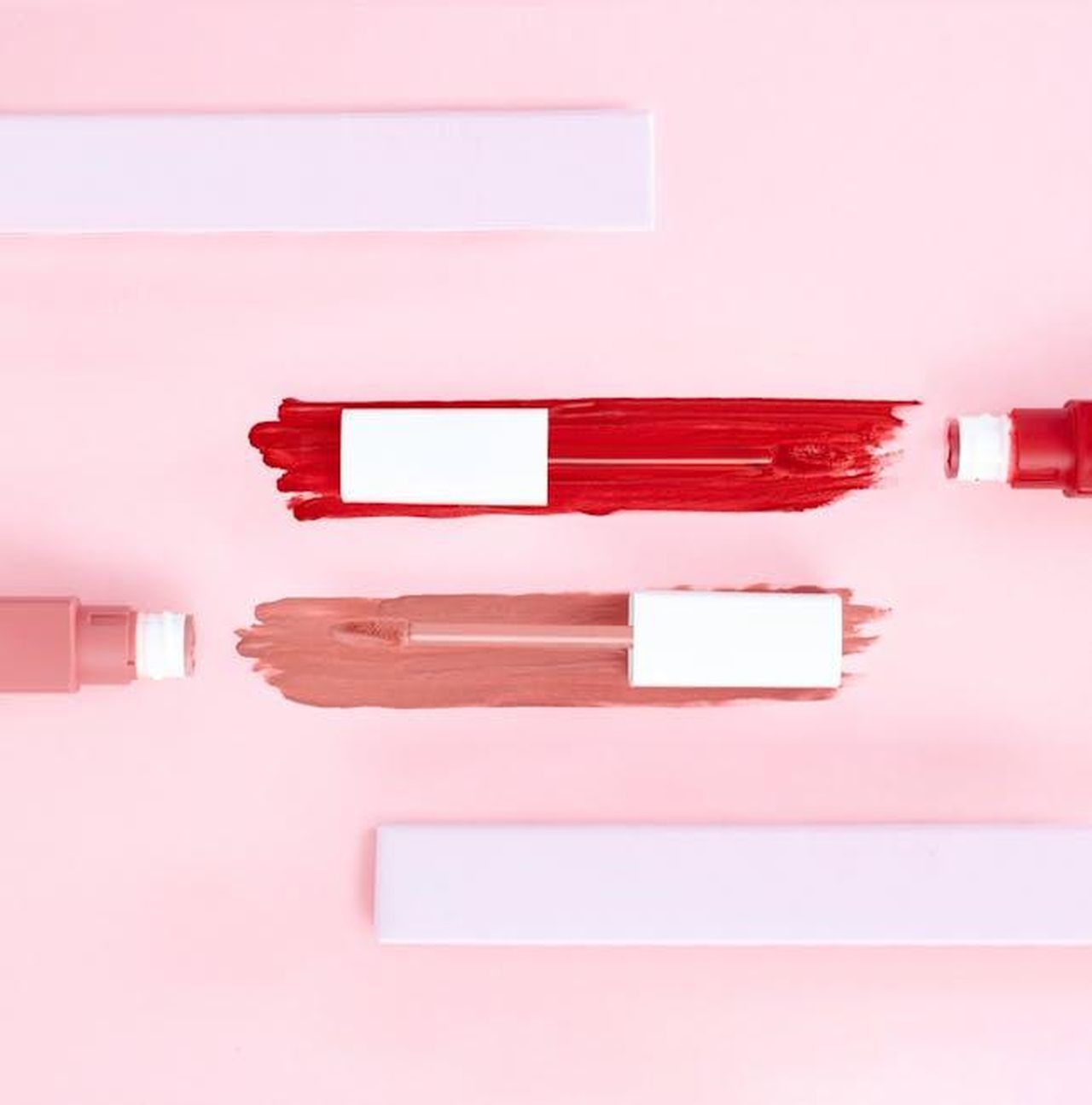 Recensioni_entusiastiche_per_il_Sheglam_Jelly_Wow_Lip_Oil_TcWF4iXeiG - Confidenze24 Source: Shiny Diamond - pexels - Top view of artistic makeup flatlay showcasing smeared lip gloss on a pink background.