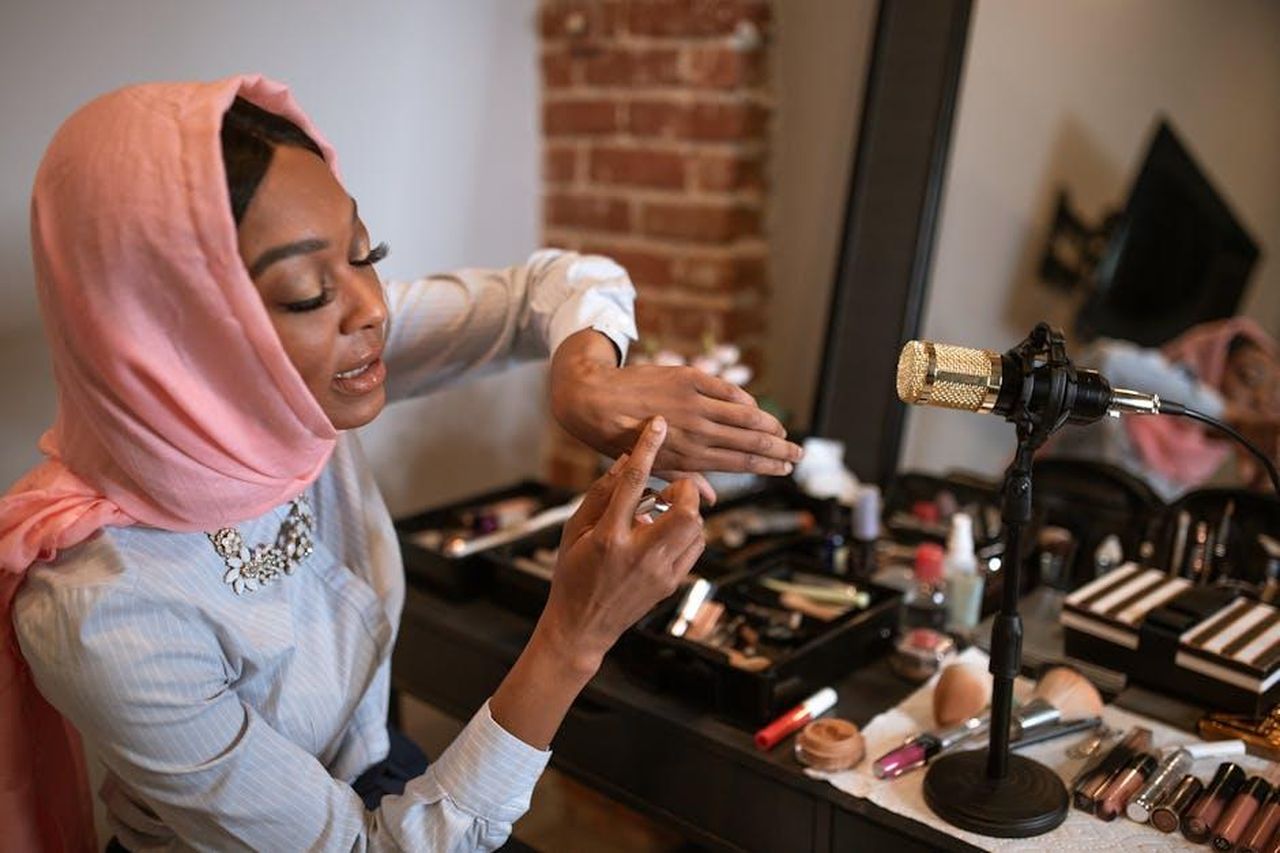 Recensioni_entusiastiche_sul_Wet_N_Wild_Mega_Last_Lip_N3pxXeBHza - Confidenze24 Source: RDNE Stock project - pexels - A stylish woman in a hijab demonstrates makeup products in front of a microphone for her fashion vlog.