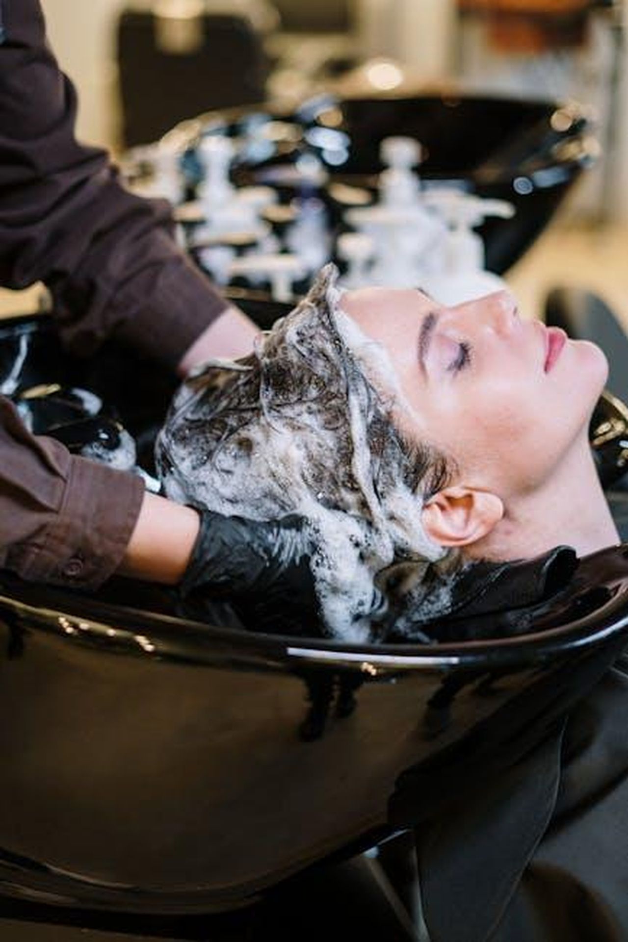 Recensioni_entusiastiche_sulla_nuova_collezione_di_Oribe_24vaM2qraM - Confidenze24 Source: cottonbro studio - pexels - Professional hair stylist washing woman's hair in a modern salon setting.