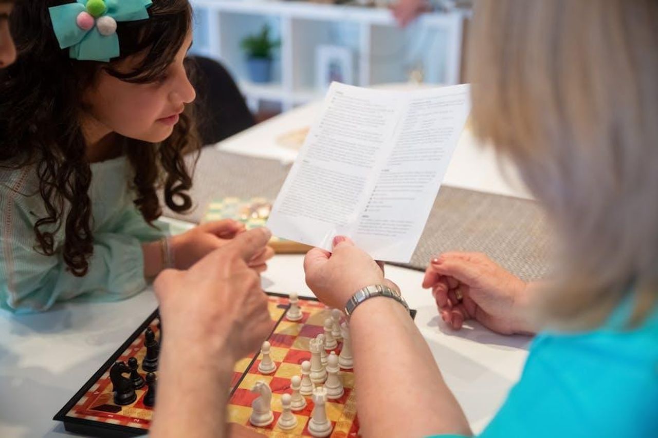 Regole_reali_e_divieti_alimentari_Ybi5Y8TbWV - Confidenze24 Source: Kampus Production - pexels - A family learning chess rules together, encouraging bonding and strategy skills.