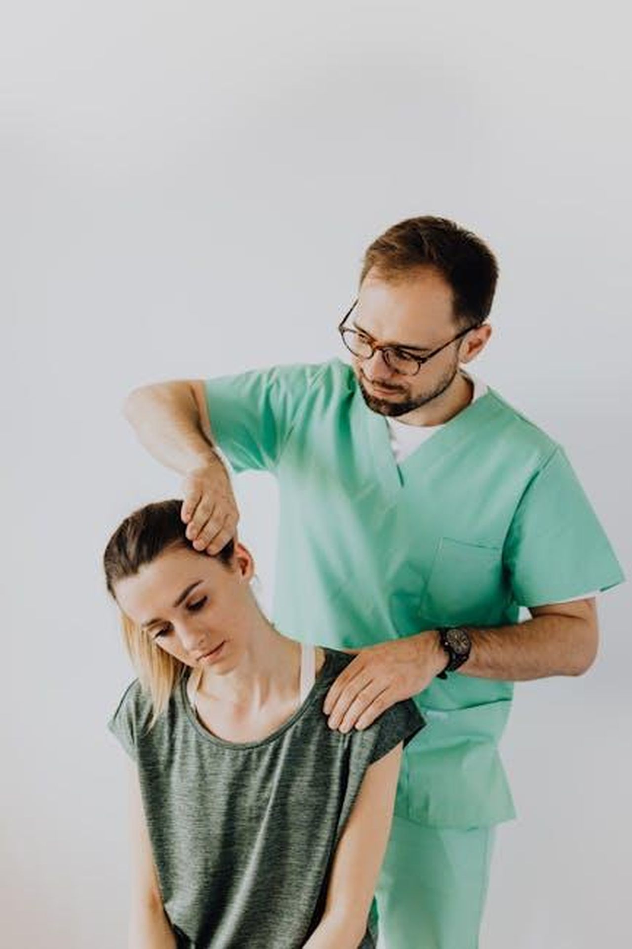 Rehab_e_trasferimento_allestero_xo3lCixIUl - Confidenze24 Source: Photo By: Kaboompics.com - pexels - A chiropractor adjusts a patient's neck to relieve pain indoors.
