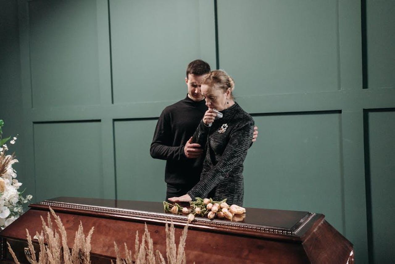 Riconoscimenti_e_Messaggi_Affettuosi_KqLY4Huj42 - Confidenze24 Source: Pavel Danilyuk - pexels - Grieving family members stand solemnly beside a coffin during a funeral.