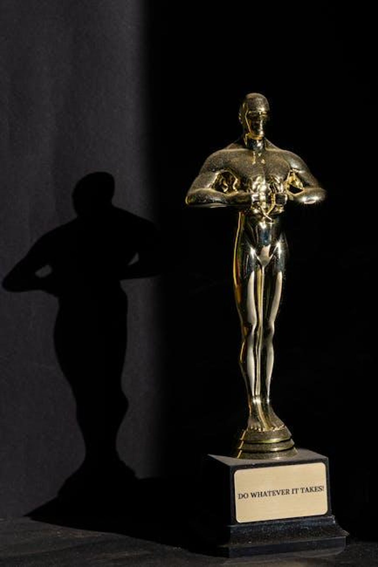 Ricordi_di_Whoopi_e_il_Suo_Oscar_del_1991_bA43Iqw7GO - Confidenze24 Source: Mirko Fabian - pexels - Close-up of a gold trophy with the message 'Do Whatever It Takes!' against a dark background.