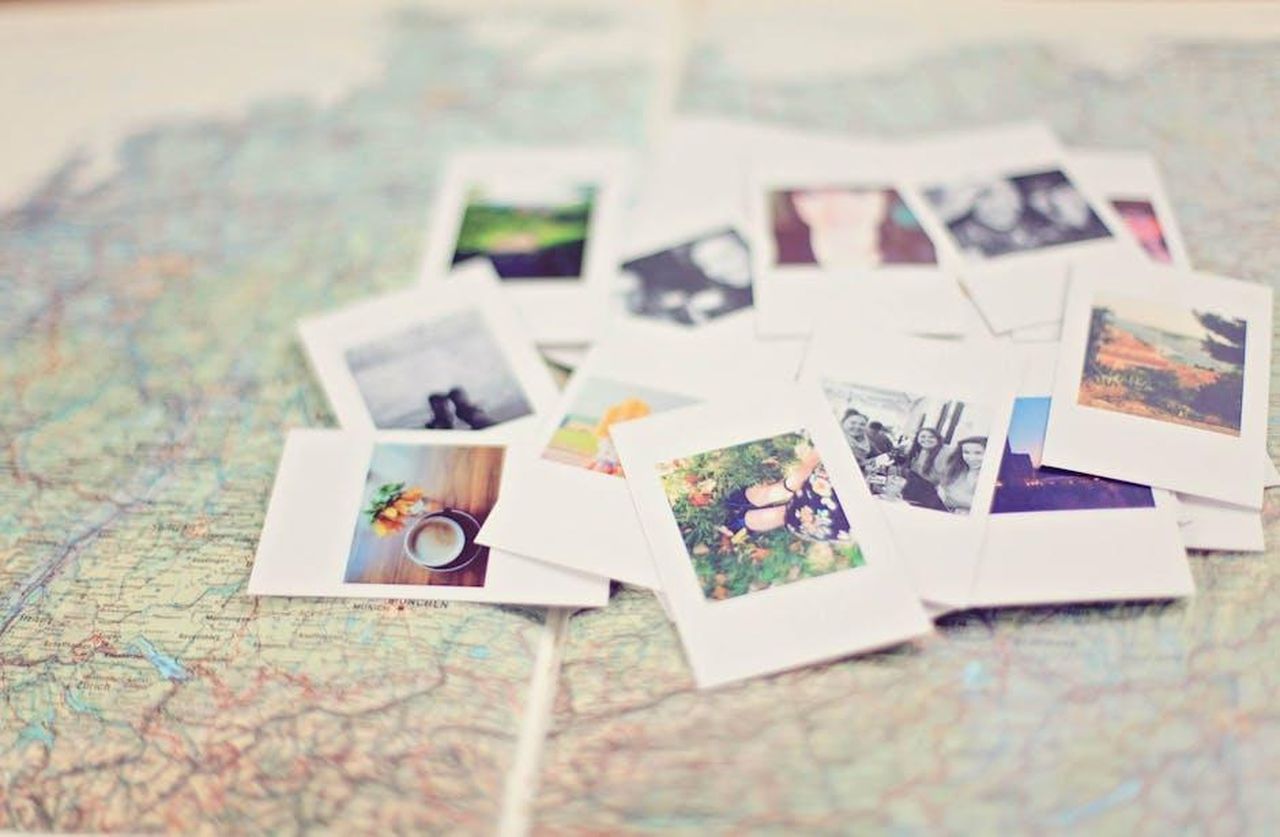 Ricordi_e_Messaggi_di_Amore_h2avaNqU7n - Confidenze24 Source: Leah Newhouse - pexels - A collection of Polaroid memories spread across a map, symbolizing travel adventures.