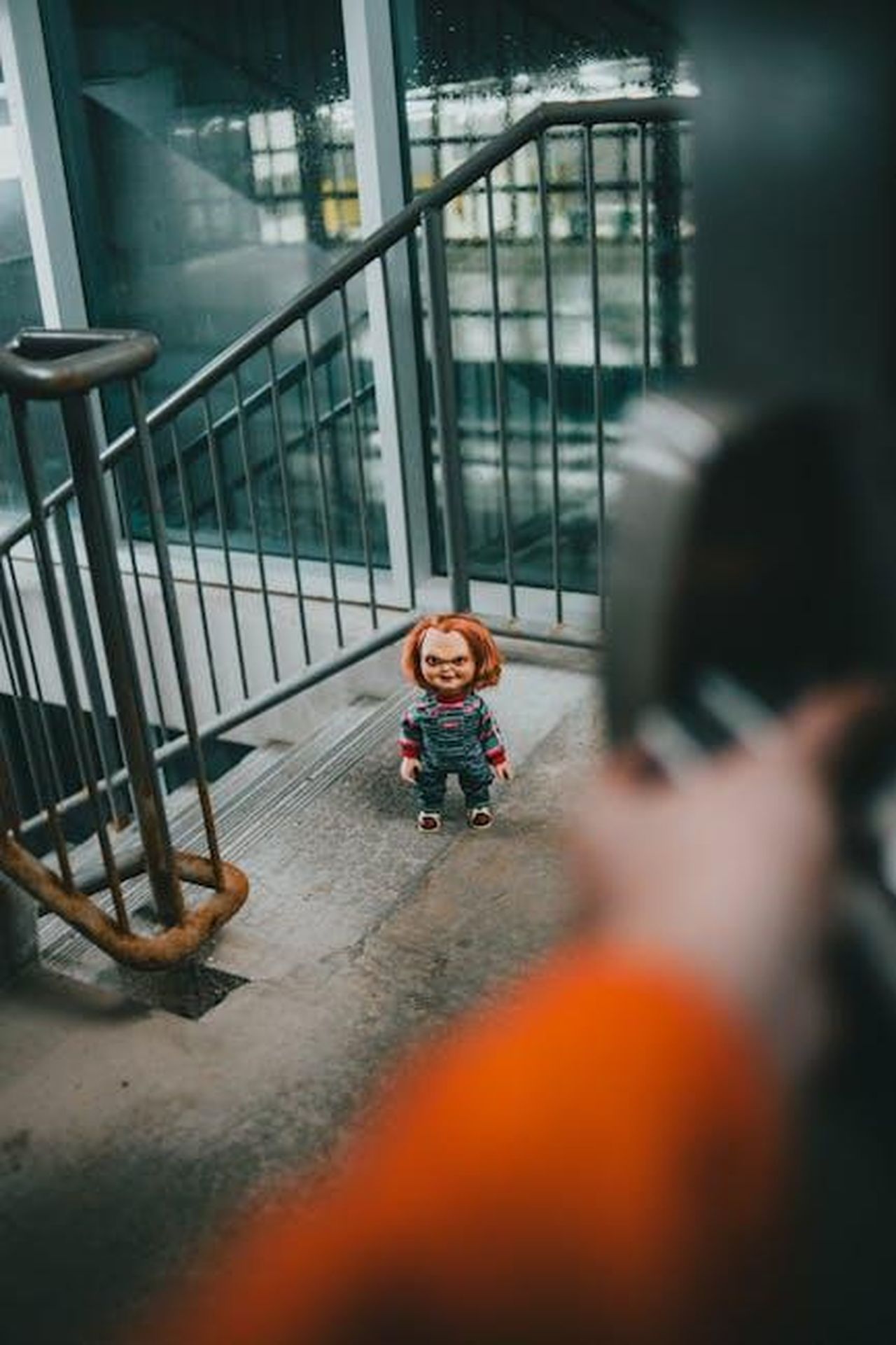 Riferimenti_alla_sua_infanzia_e_alla_famiglia_7Zc9g4UeQ4 - Confidenze24 Source: Erik Mclean - pexels - A doll with an eerie expression stands on an industrial staircase.