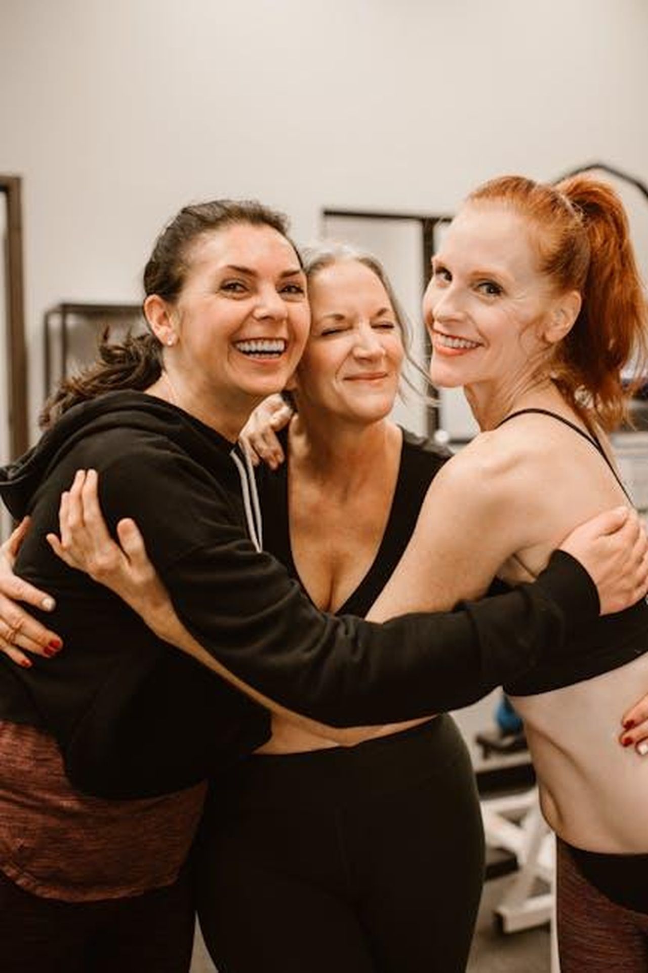 Riflessioni_di_Emma_sulla_maternit_e_lesercizio_postpartum_cjNOBL9HrP - Confidenze24 Source: RDNE Stock project - pexels - Three happy women hugging at the gym, celebrating friendship and wellness.