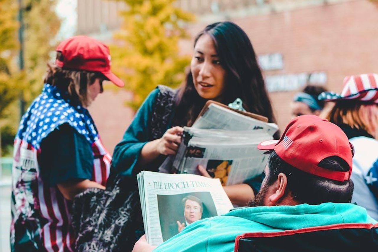 Riflessioni_e_reazioni_sui_social_OKTpFXzV8Q - Confidenze24 Source: Rosemary Ketchum - pexels - A group of adults reading newspapers outdoors, immersed in political discussions on a vibrant day.