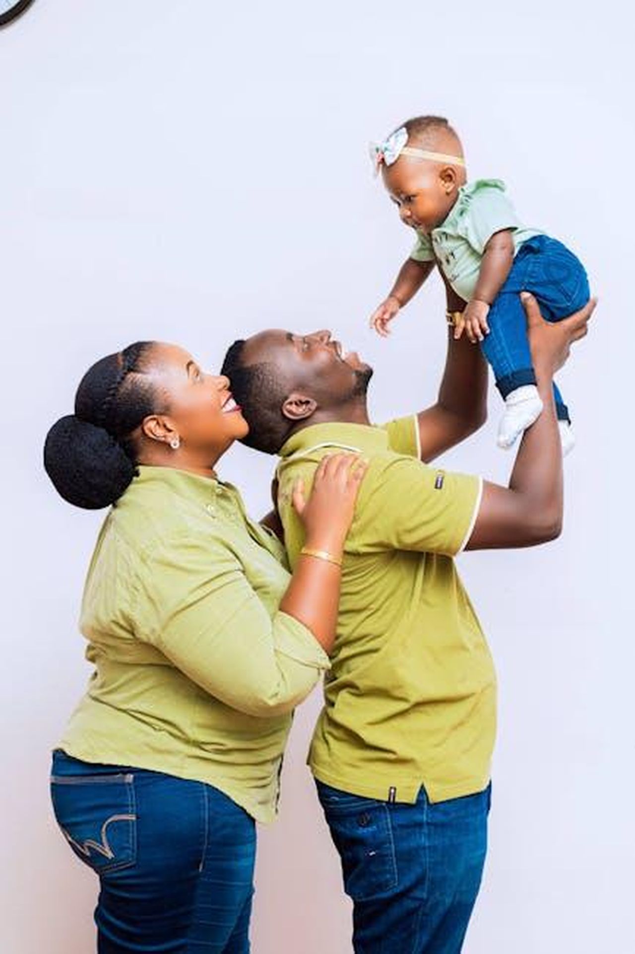 Riflessioni_sul_passato_e_supporto_familiare_m476IP0FKT - Confidenze24 Source: Safari Consoler - pexels - Joyful family playing with their baby, all wearing green and denim outfits.