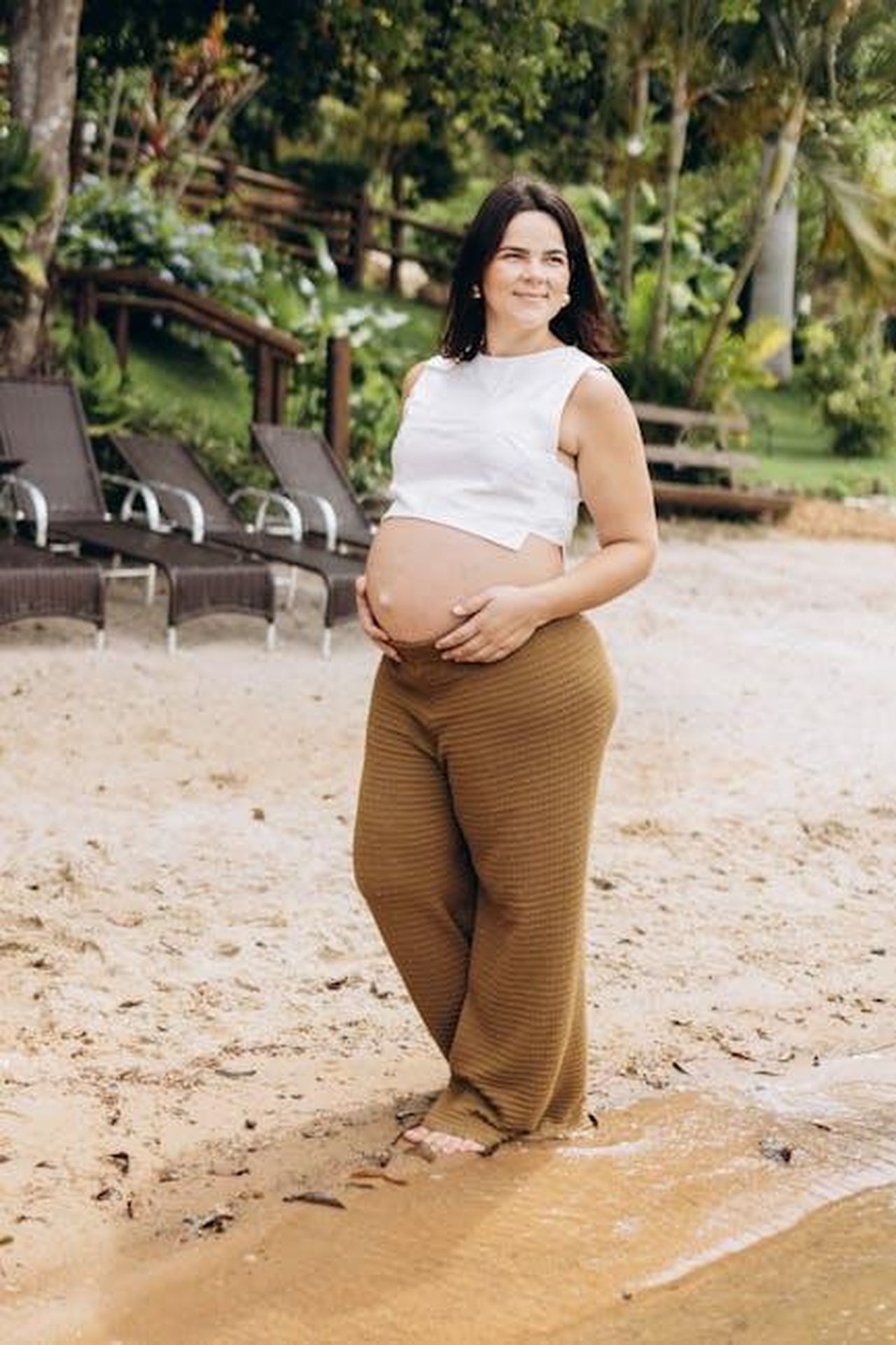 Riflessioni_sulla_vita_e_la_felicit_hHwICrinXJ - Confidenze24 Source: Jonathan Borba - pexels - A pregnant woman standing barefoot on a sandy beach, embracing nature's beauty.