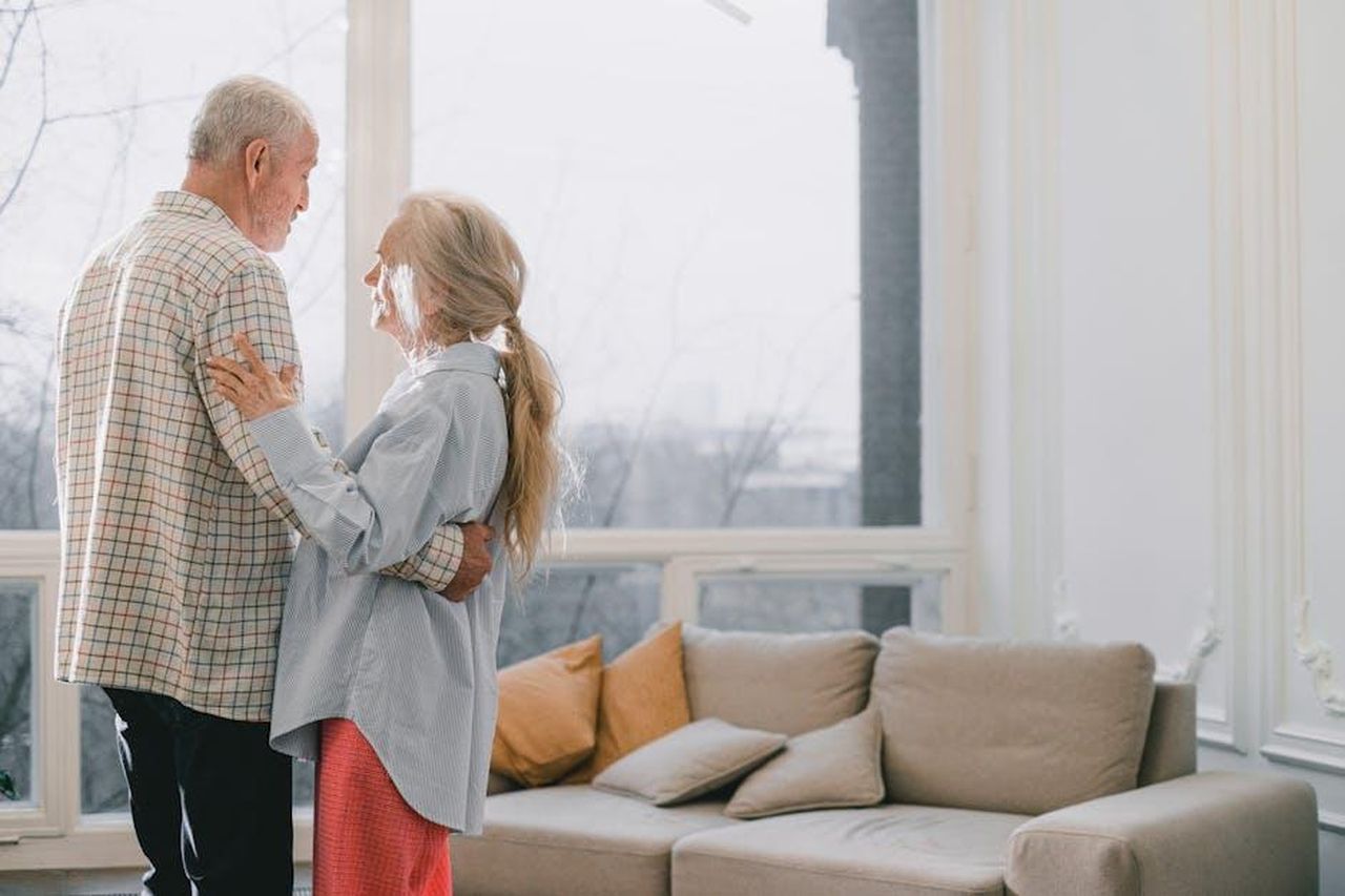 Riflessioni_sulla_vita_e_lamore_8MnXEKq9pm - Confidenze24 Source: SHVETS production - pexels - A senior couple shares a tender dance in a bright, cozy living room.