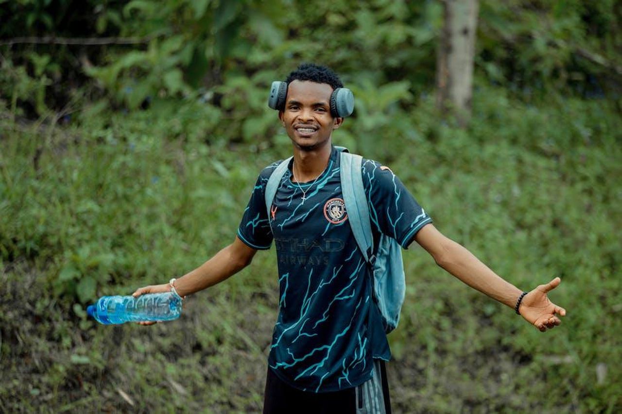 Rimanere_attivi_alhZfYYZI3 - Confidenze24 Source: Chris wade NTEZICIMPA - pexels - Smiling young man with headphones and water bottle enjoying an outdoor walk.