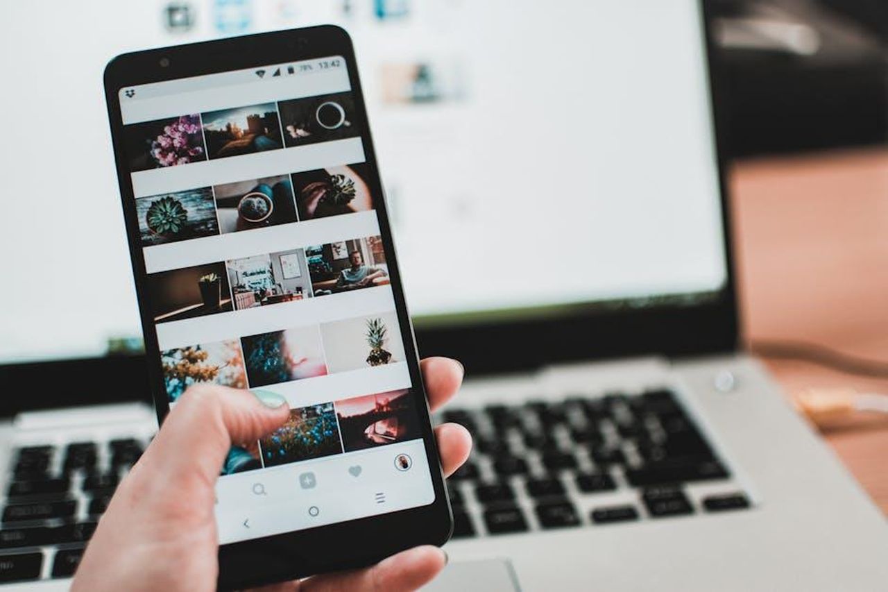 Risposta_di_Maya_Jama_a_un_troll_su_Twitter_d25FLeL9wX - Confidenze24 Source: Lisa from Pexels - pexels - A person uses a smartphone to browse social media in front of a laptop, emphasizing modern technology and lifestyle.