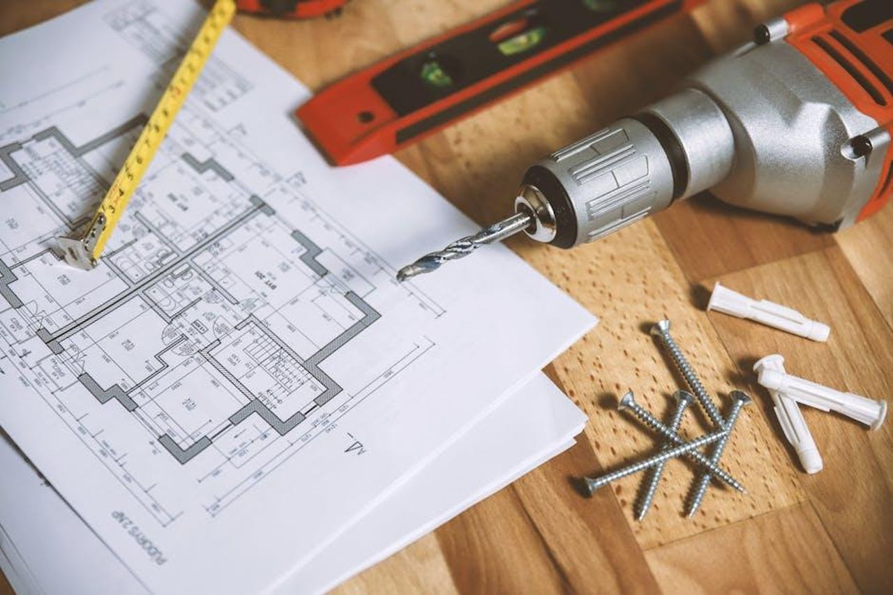 Ristrutturazioni_e_cambiamenti_a_Sebring_Florida_xPDN7LdTrO - Confidenze24 Source: JESHOOTS.com - pexels - Close-up of construction blueprint with tools like drill and screws on a wooden table.