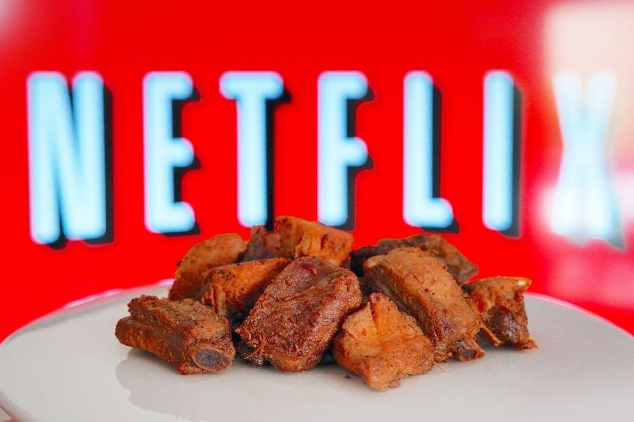 Ritorno_di_Little_Britain_p2yftjl42W - Confidenze24 Source: René Roa - pexels - Plate of roasted beef ribs in front of a bright Netflix screen, perfect for a cozy night in.