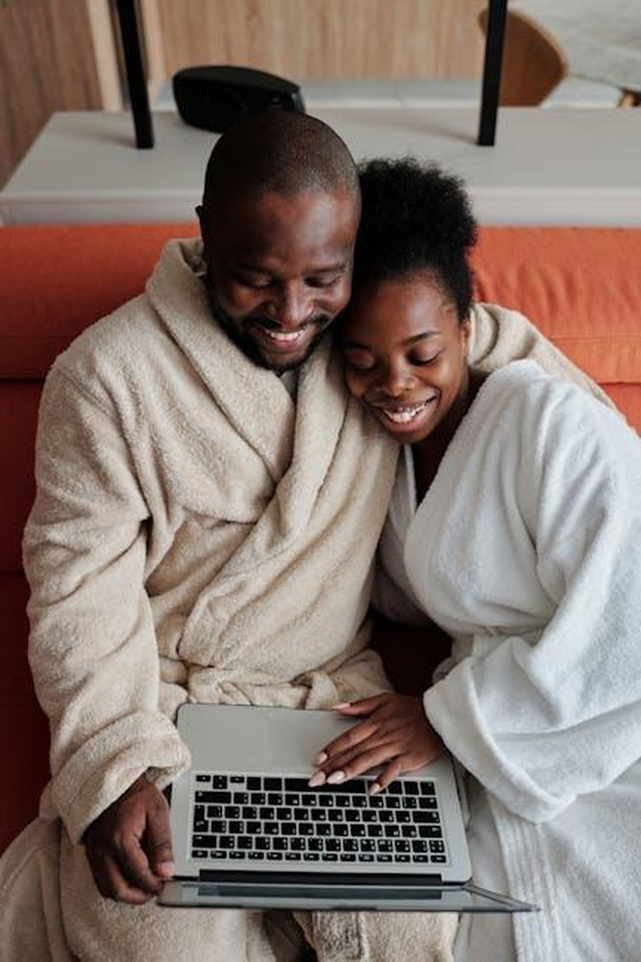 Riunione_della_famiglia_Duggar_e_notizie_su_Sudiksha_Konanki_TD1bqAt3uZ - Confidenze24 Source: Diva Plavalaguna - pexels - A joyful couple in bathrobes sharing a moment while browsing on a laptop indoors.