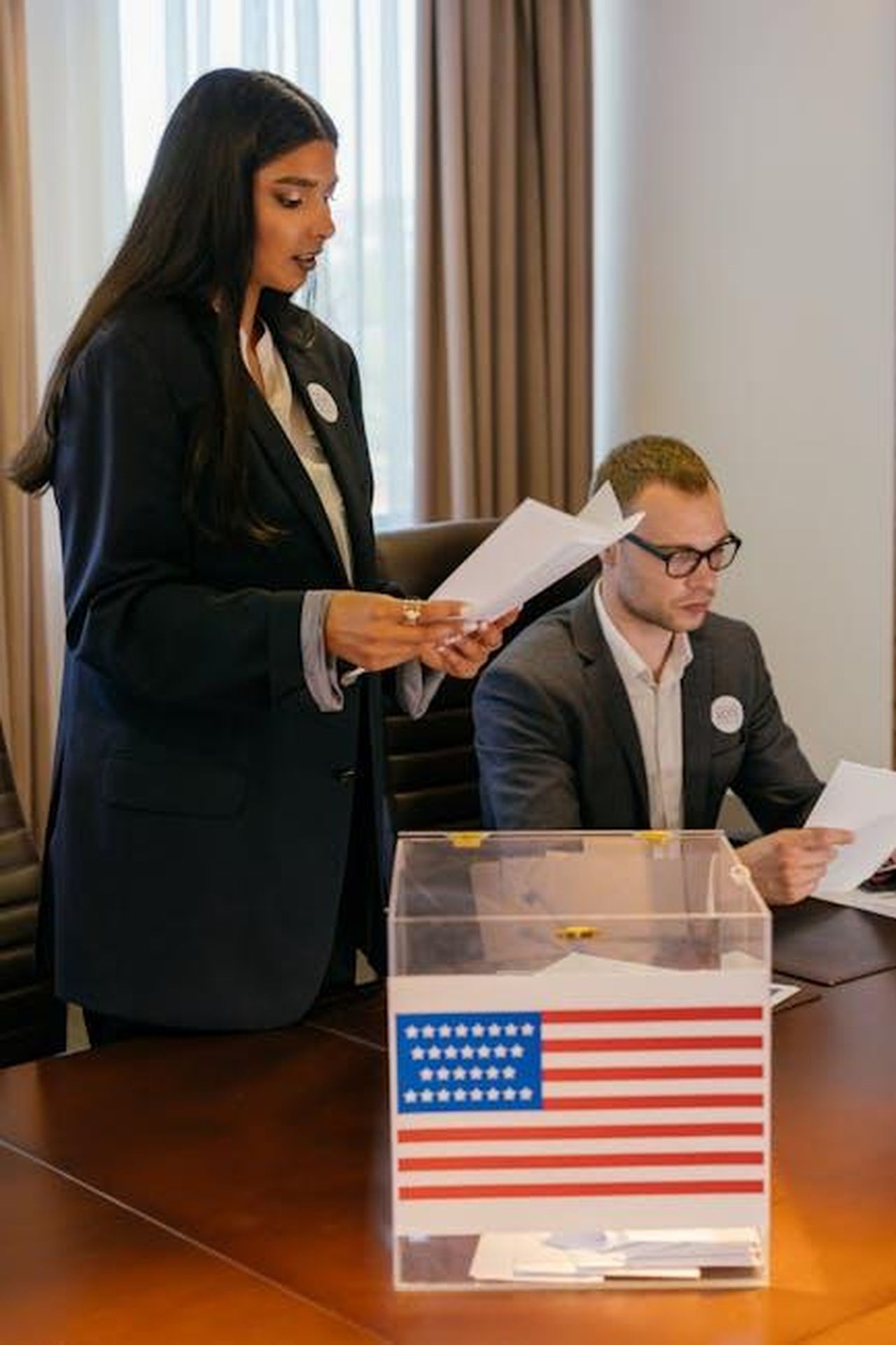 Rivalit_riemersa_durante_linaugurazione_di_Trump_r53DycXl02 - Confidenze24 Source: Mikhail Nilov - pexels - Diverse professionals in a meeting room reviewing ballots with a voting box.