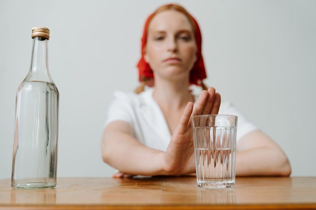 Rivelazione_del_2023_da_Linda_Nolan_ImuiXmAmej - Confidenze24 Source: cottonbro studio - pexels - A woman with a red kerchief rejects a glass of alcohol, symbolizing sobriety or refusal.