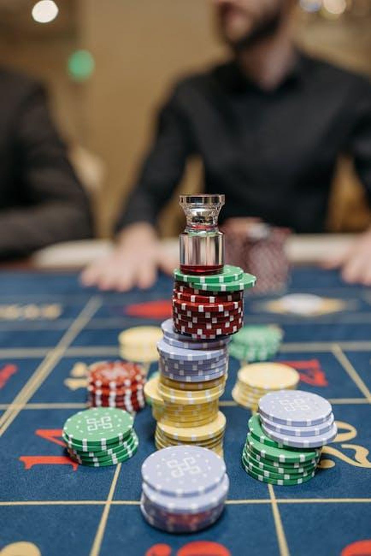 Roman_Kemp_parla_della_perdita_di_un_milione_di_sterline_ya4YzTzkE2 - Confidenze24 Source: Pavel Danilyuk - pexels - Close-up of colorful casino chips stacked on a roulette table in a casino setting.