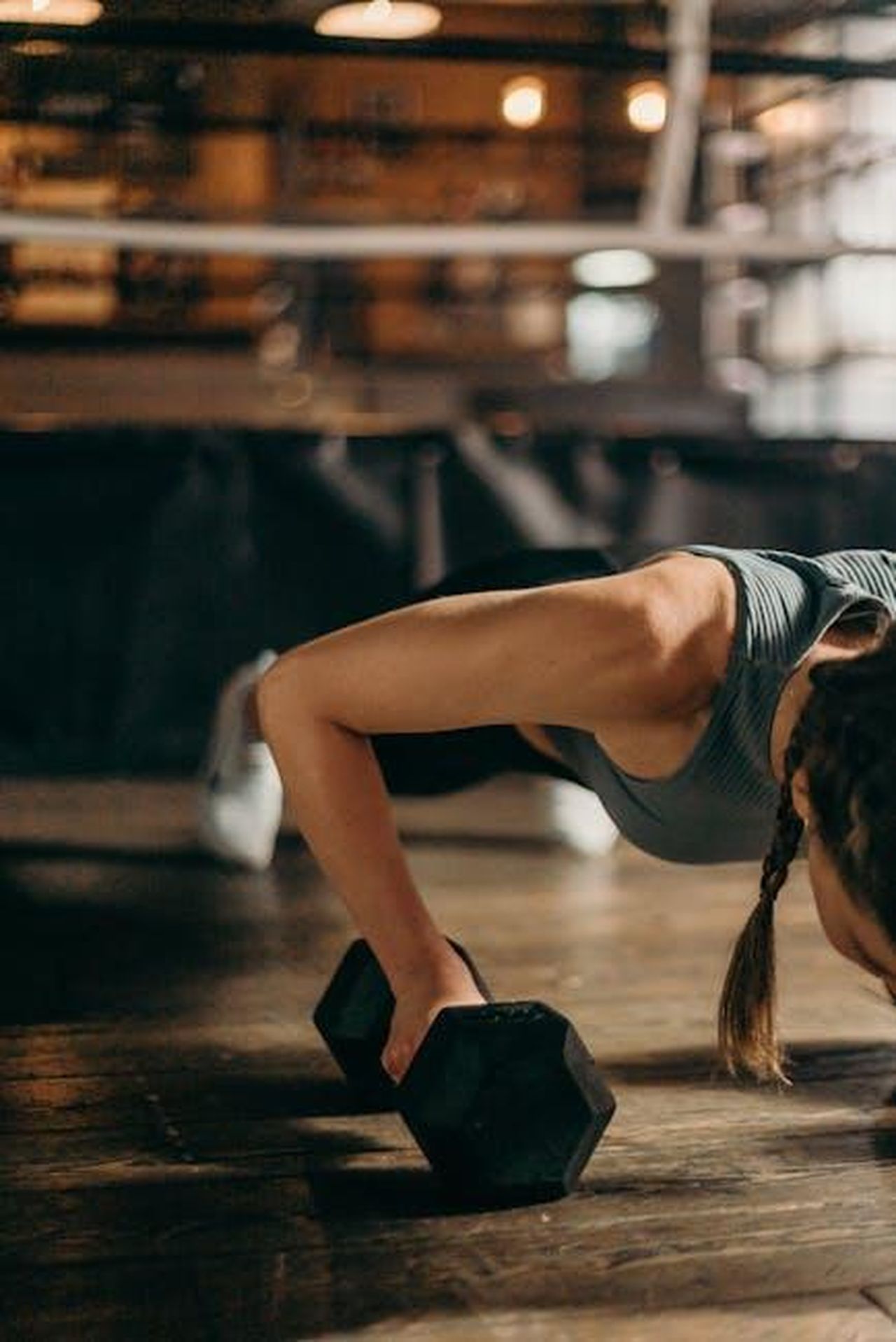 Routine_di_allenamento_Umr2azpB2G - Confidenze24 Source: cottonbro studio - pexels - Fit woman doing a dumbbell push-up in a gym, highlighting strength and fitness training.