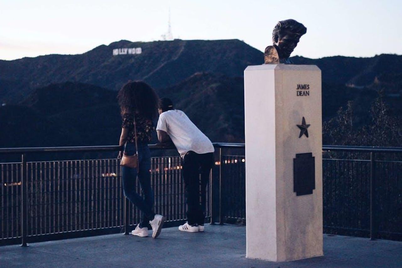 Rumori_di_Relazione_Teyana_e_Aaron_CMuUuzOtP4 - Confidenze24 Source: nappy - pexels - A couple admires the Los Angeles landscape from a view deck near a James Dean sculpture.